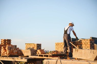 Installing brick wall. Construction worker in uniform and safety equipment have job on building.