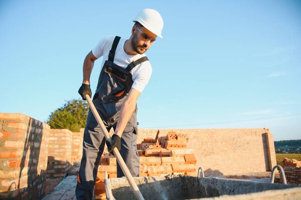 Man bricklayer installing bricks on construction site.