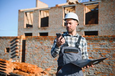 Açık havada inşaat alanında çalışan bir inşaatçının portresi..