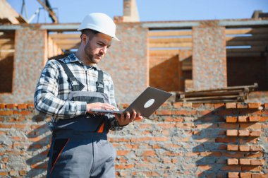 Açık havada inşaat alanında çalışan bir inşaatçının portresi..