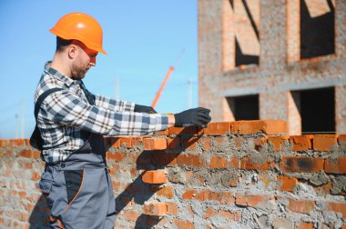 Açık havada inşaat alanında çalışan bir inşaatçının portresi..
