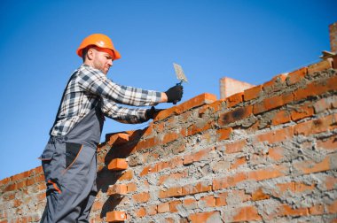 Çimento Sanayi işçisi tuğla duvar dış duvarda mala macun bıçak ile yükleme.