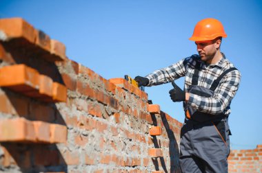 Construction worker in uniform and safety equipment have job on building.