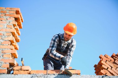 Construction worker in uniform and safety equipment have job on building.