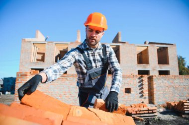 Açık havada inşaat alanında çalışan bir inşaatçının portresi..