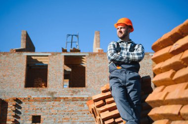 Açık havada inşaat alanında çalışan bir inşaatçının portresi..