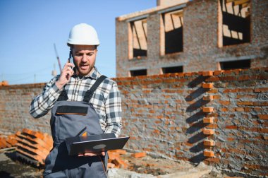 Açık havada inşaat alanında çalışan bir inşaatçının portresi..