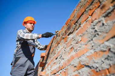Açık havada inşaat alanında çalışan bir inşaatçının portresi..