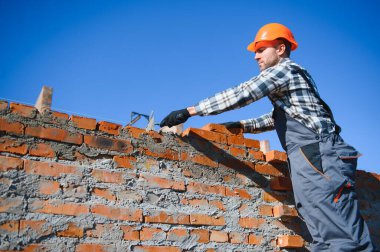 Construction worker in uniform and safety equipment have job on building.