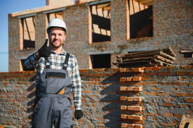 Çimento Sanayi işçisi tuğla duvar dış duvarda mala macun bıçak ile yükleme.