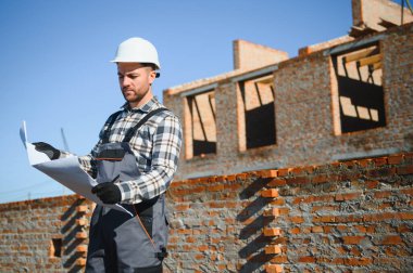 Açık havada inşaat alanında çalışan bir inşaatçının portresi..