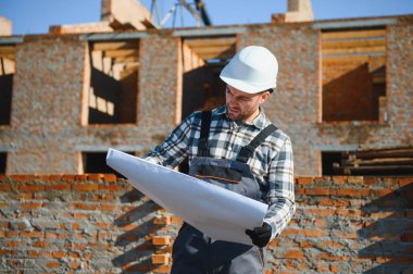 Açık havada inşaat alanında çalışan bir inşaatçının portresi..