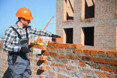 Çimento Sanayi işçisi tuğla duvar dış duvarda mala macun bıçak ile yükleme.