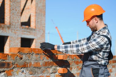 Construction worker in uniform and safety equipment have job on building.