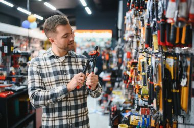 Hırdavatçıda bir adam bir araç seçiyor..