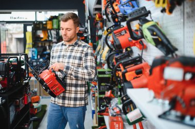 Hırdavatçıda bir adam bir araç seçiyor..