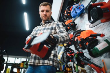 Adam alet deposundan elektrikli testereyi seçiyor..