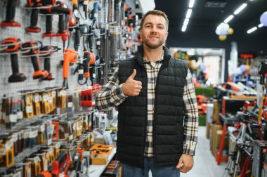 Hırdavatçıda bir adam bir araç seçiyor..