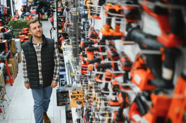 Hırdavatçıda bir adam bir araç seçiyor..