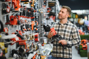 Hırdavatçıda bir adam bir araç seçiyor..