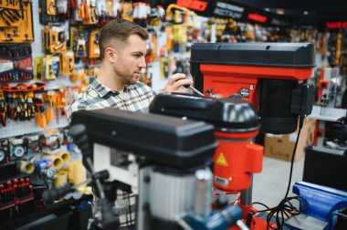 Hırdavatçıda bir adam bir araç seçiyor..