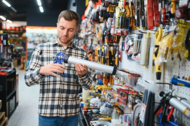 Modern bir hırdavatçıda erkek bir müşteri silikon silah seçiyor..