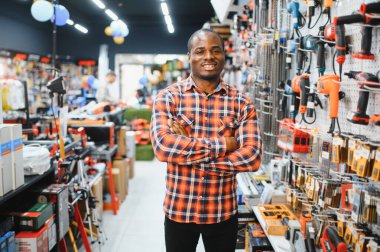 Afrikalı bir Amerikalı hırdavatçıdan elektrikli bir alet seçiyor..