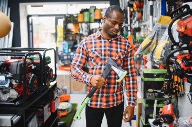 Genç bir adam hırdavatçıda balta seçiyor..