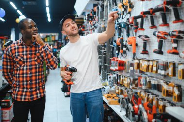Satış danışmanı, müşteriye hırdavatçıda tornavida seçmesinde yardımcı olur..