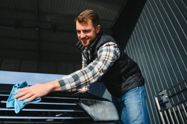 Mikrofiber bezle erkek silme aracı. Araba yıkama konsepti.