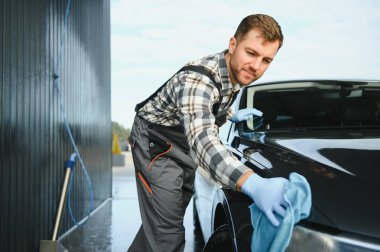 Araba ayrıntılı - adam mikrofiber elinde tutan ve araba parlatır. Seçici odak.