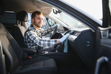 Araba yıkamacıdaki işimde harika bir iş çıkardığım için mutluyum. Müşteri aracında oturan bir adamın portresi.