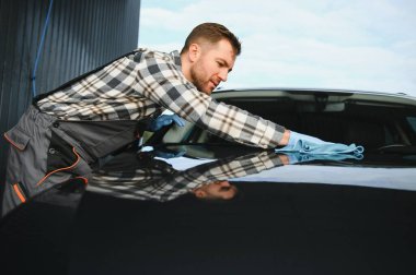 Erkek işçi araba yıkama servisi. Araba yıkama istasyonu yüksek basınçlı su. Çalışanlar bir aracı profesyonel olarak temizler.