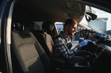 Araba yıkamacıdaki işimde harika bir iş çıkardığım için mutluyum. Müşteri aracında oturan bir adamın portresi.