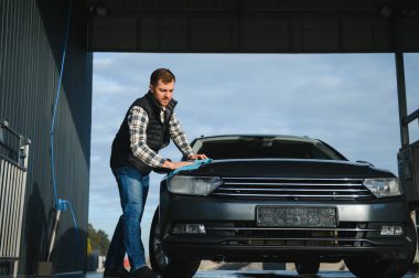 Mikrofiber bezle erkek silme aracı. Araba yıkama konsepti.