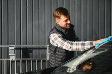 Mikrofiber bezle erkek silme aracı. Araba yıkama konsepti.