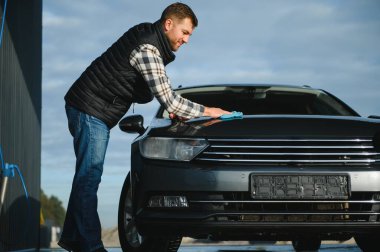 Mikrofiber bezle erkek silme aracı. Araba yıkama konsepti.