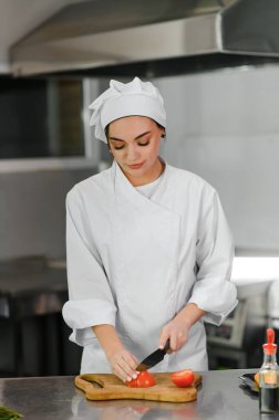 Güzel bir bayan şef bir restoranın ya da otelin mutfağında çalışıyor..