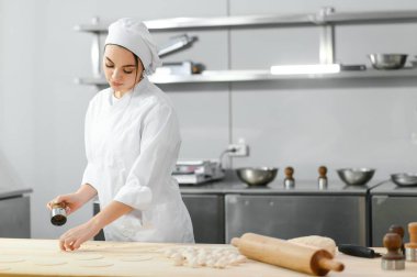 Mutfak işçisi kıymalı hamurdan hamur köftesi yapıyor..