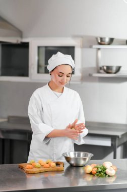 Güzel bir bayan şef bir restoranın ya da otelin mutfağında çalışıyor..