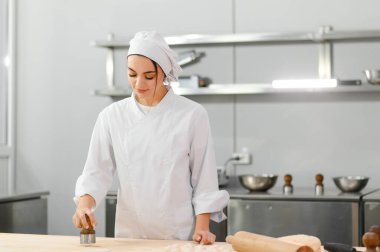 Kadın aşçı mutfakta hamur yoğurur. Yarı bitmiş ürünler kavramı.