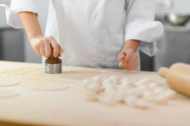 Mutfak işçisi kıymalı hamurdan hamur köftesi yapıyor..