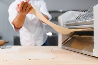 Adam makarna mutfak masasının üzerine hazırlanıyor.