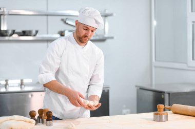 Profesyonel mutfakta khinkali yapan yakışıklı bir aşçı. Yarı bitmiş ürünler kavramı