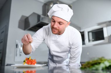 Kafkasyalı mutlu aşçının portresi restoranın mutfağında duruyor..