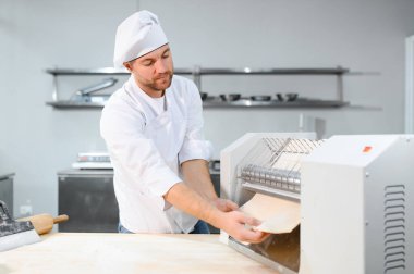 Adam makarna mutfak masasının üzerine hazırlanıyor.