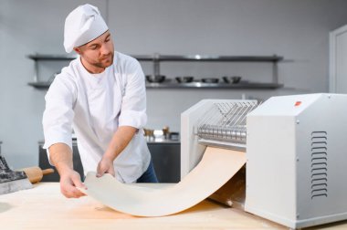 Adam makarna mutfak masasının üzerine hazırlanıyor.