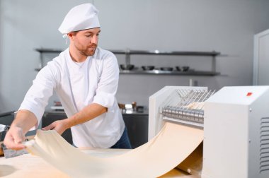 Adam makarna mutfak masasının üzerine hazırlanıyor.