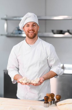 Profesyonel mutfakta khinkali yapan yakışıklı bir aşçı. Yarı bitmiş ürünler kavramı