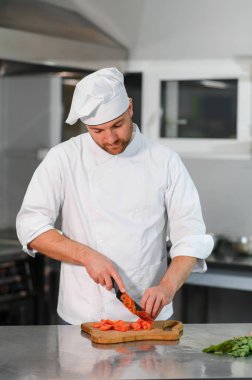 Kafkasyalı mutlu aşçının portresi restoranın mutfağında duruyor..